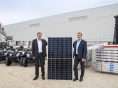 Achim Heinfling, az Audi Hungaria Zrt. igazgatóságának elnöke (bal oldalon) és Kiss Attila, az E.ON Hungária Zrt. elnök-vezérigazgatója tartja kezében az épület tetejére felkerülő napelemek egyikét